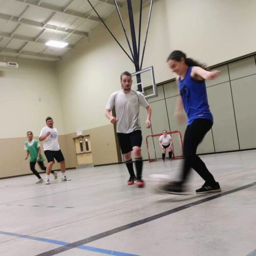 People playing soccer in a community gym