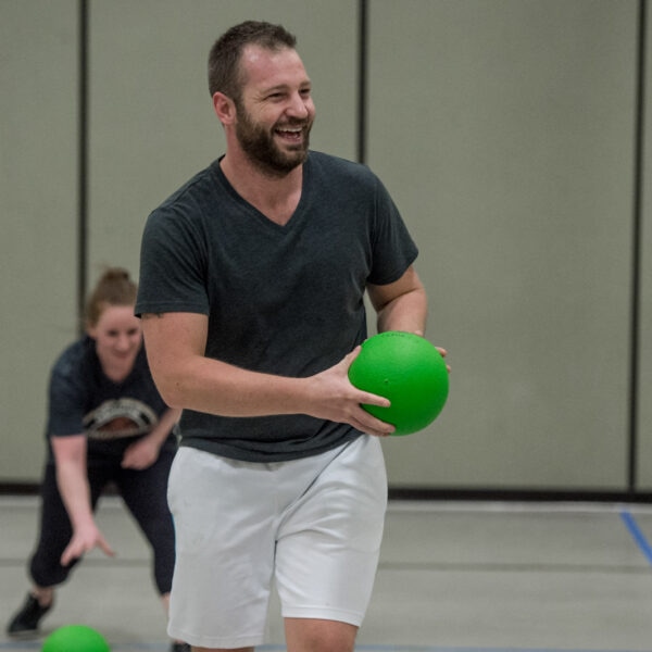 Dodgeball player smiling with a ball in his hands.
