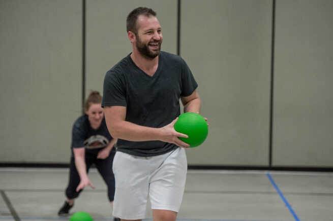Dodgeball player smiling with a ball in his hands.