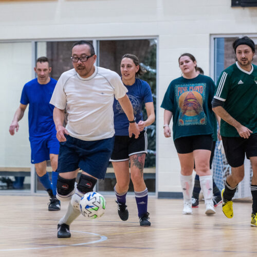 Adults playing indoor soccer.