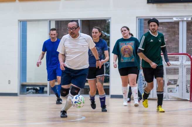 Adults playing indoor soccer.